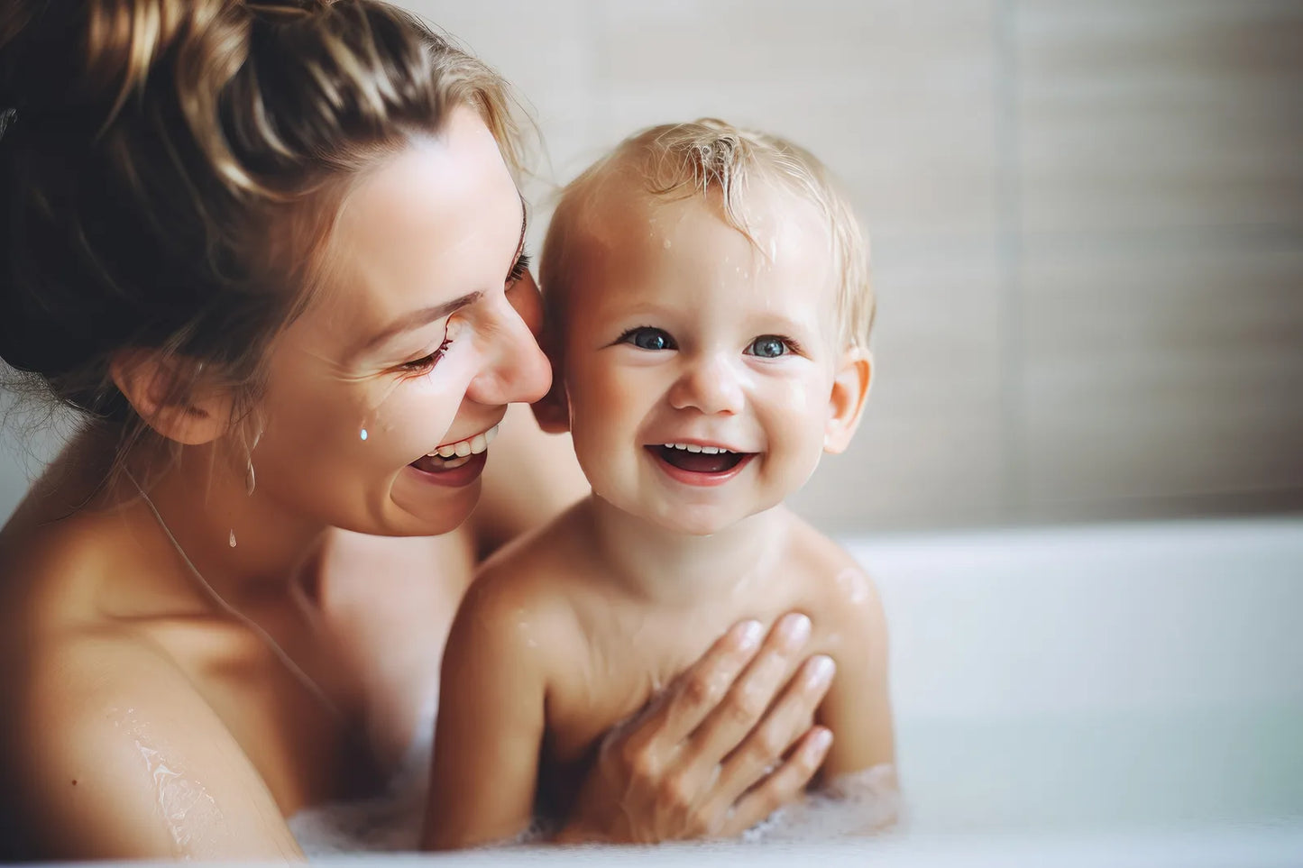 Mother bathing a laughing toddler