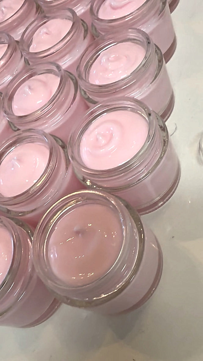 Jars of pink cream during the filling process
