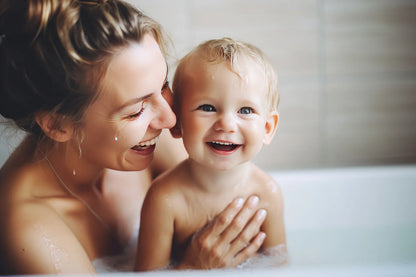 Mother bathing a laughing toddler