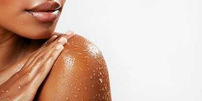 Model smoothing cleanser over a wet shoulder dotted with water droplets